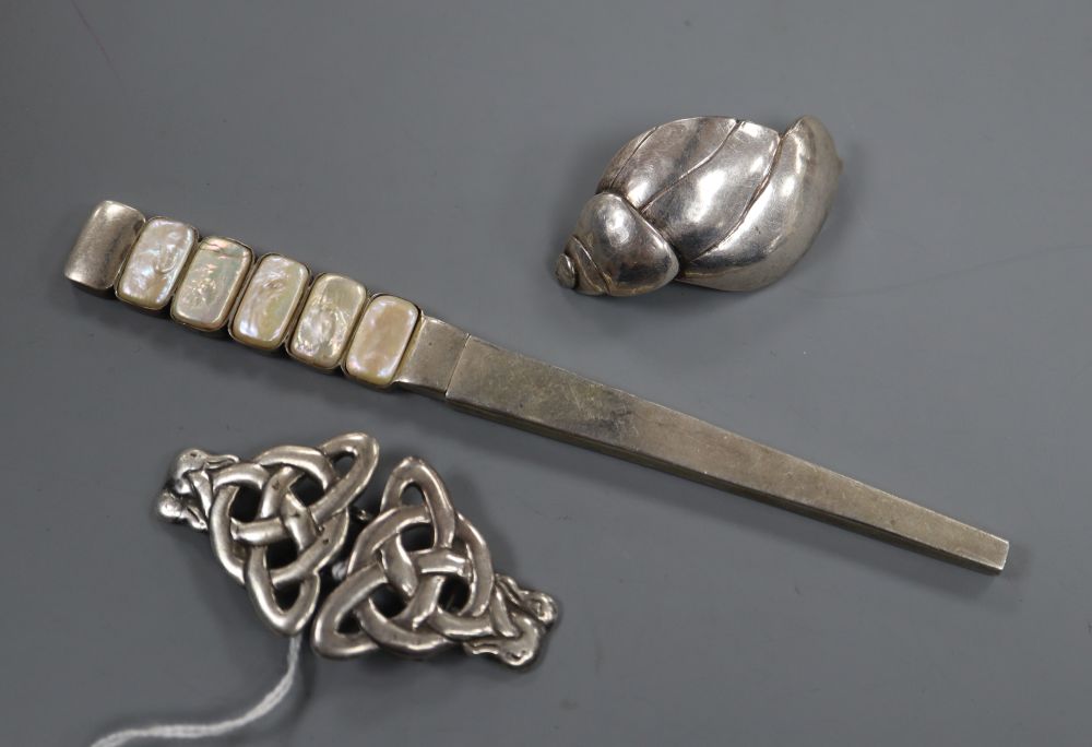 A stylish mother of pearl and 925 hair ornament, a stylish 1930s silver buckle and a white metal shell brooch.